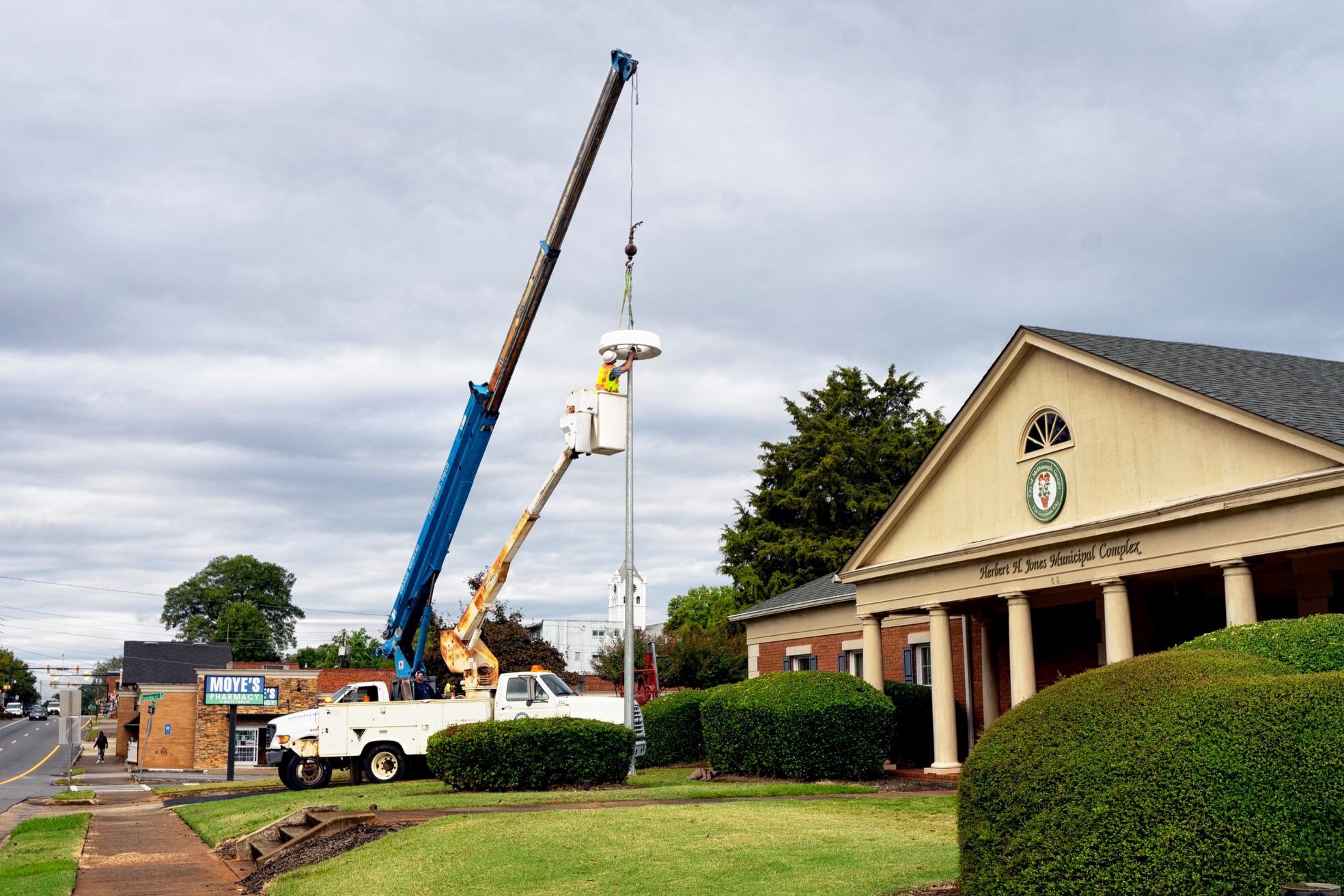 Photo of McDonough staff installing a solar-powered light outside McDonough Fire Station 51 (city photo)