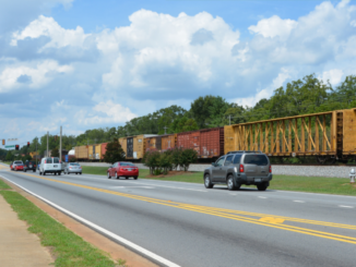 Photo of downtown Locust Grove with cargo train in the background (Henry County photo).