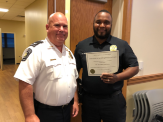 Photo of Locust Grove Police Officer Demarkus Hutcherson receiving a certificate of appreciation from Police Chief Derrick Austin (Locust Grove photo)