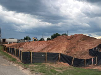 Photo shows construction silt fencing, dirt piles and heavy equipment at the site of the future RaceTrac service station on highway 155 in McDonough in July 2022 (Clayton Carte photo).