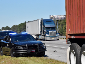 Photo shows two Motor Carrier Compliance Division officers stopped behind a tractor-trailer on the side of the interstate (Georgia photo).