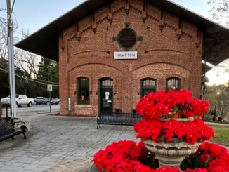 Photo of Hampton train depot with poinsettias in fountain for Christmas season (Clayton Carte photo).
