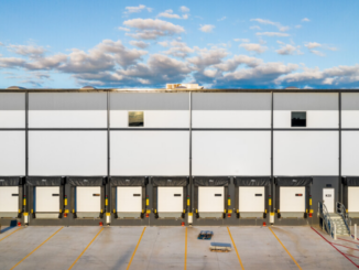 Photo shows dock doors on the side of a distribution building (real estate photo).