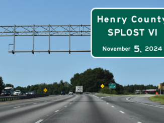 Photo shows Interstate 75 and overhead road sign with “Henry County SPLOST VI November 5, 2024” (AA Roads photo / Sign Maker by Brendon Stowe sign).